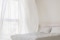 The picture shows a bedroom with an open window and billowing curtains.